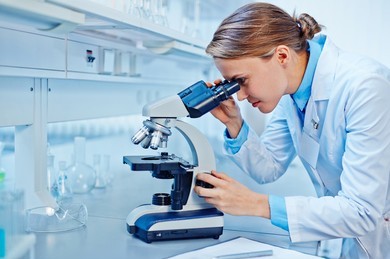 female-scientist-looking-through-microscope-260nw-395017156